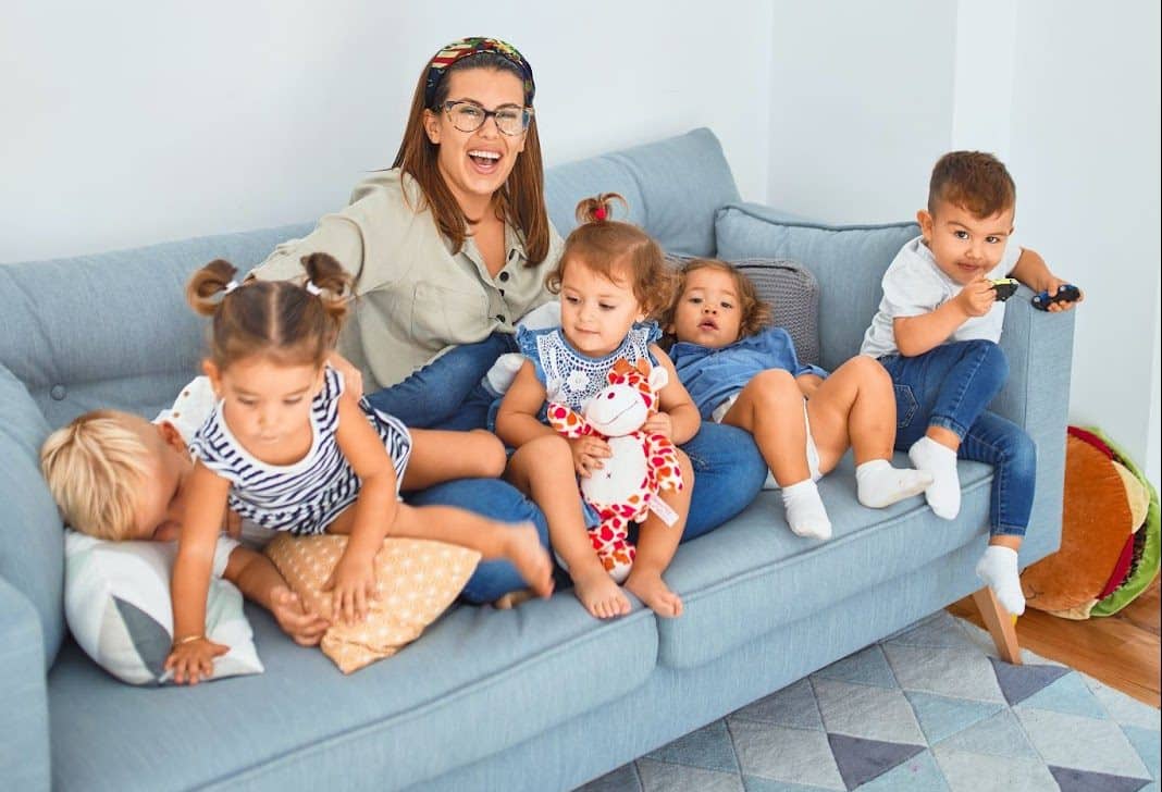 Woman with 5 children on sofa - The Benefits of Childcare for toddlers