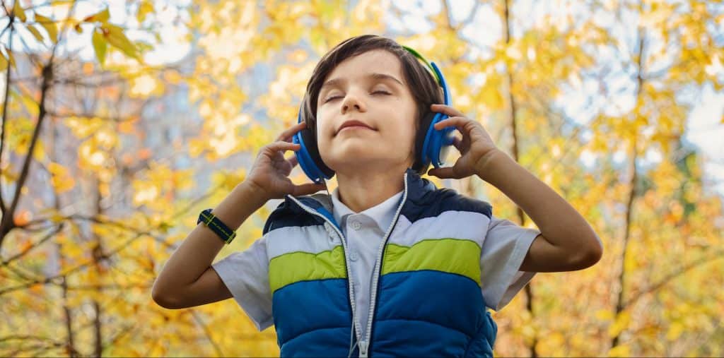 Toddler listening through headphones to improve listening skills